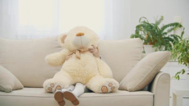 4K yavaş çekim videosunda küçük kız peluş bir oyuncak ayı tutuyor..