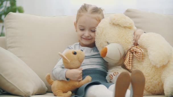 4k сповільнення крупним планом відео маленької дівчинки з плюшевими іграшками дивиться на камеру . — стокове відео