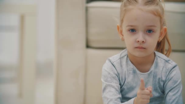 4k slow motion vídeo de pequena garota séria com olhos azuis olhando para a câmera. — Vídeo de Stock