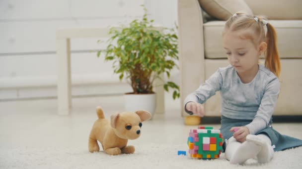 4k video de niña pequeña en el suelo jugando con juguete. — Vídeo de stock