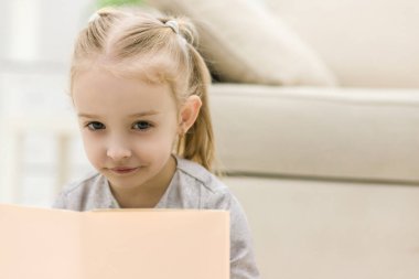 Tatlı mutlu küçük kız kitap okuyor..