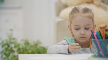 4k yakın çekim videosunda elinde pastel boyalarla evde bir şeyler çiziyor..
