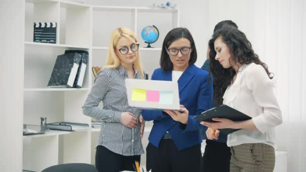 4k video van jonge teamleider staande aan tafel met collega 's. — Stockvideo