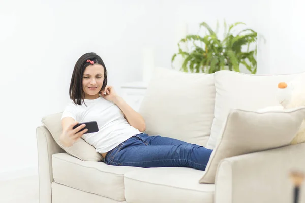 Foto de una mujer sonriente acostada en un sofá haciendo selfie. —  Fotos de Stock