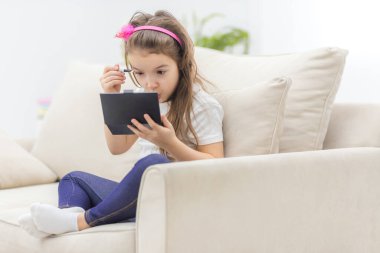 Aynaya bakan sevimli küçük bir kızın fotoğrafı..