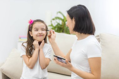 Anne ve kızının oturma odasında makyaj yaparken çekilmiş bir fotoğrafı..