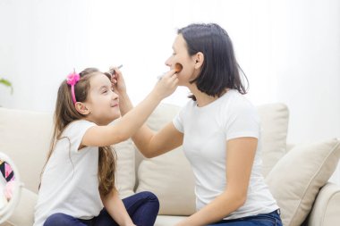 Güzel anne kızına evde makyaj yapmayı öğretiyor..