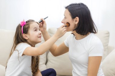 Güzel anne kızına evde makyaj yapmayı öğretiyor..