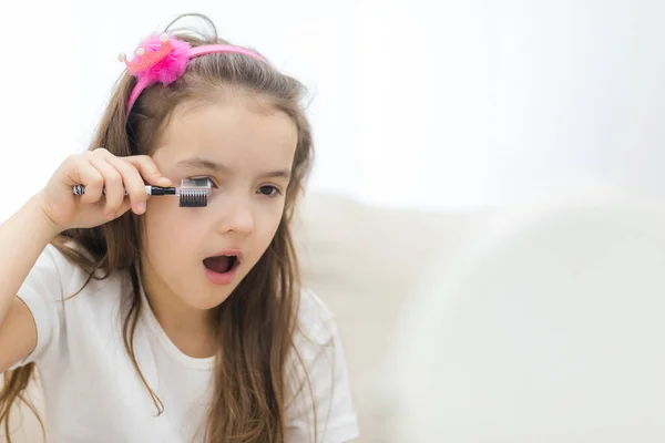 Foto de adorable niña aplicando maquillaje. —  Fotos de Stock