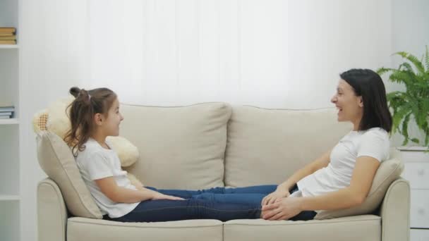 4k slow motion vídeo de filha e mãe deitada no sofá branco na sala de estar. — Vídeo de Stock