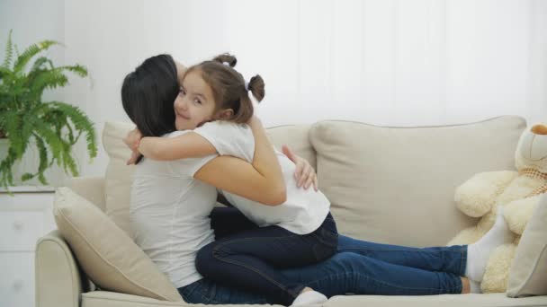 Söpö suloinen tytär ja nuori äiti leikkii sohvalla kotona. — kuvapankkivideo