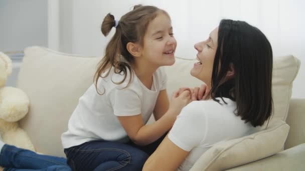 4k lassított felvétel szép anya és gyönyörű lánya ül a kanapén. — Stock videók