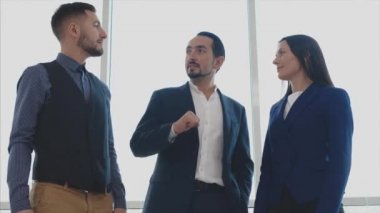 Erkek ve kadın işçiler ellerini birleştiriyor. Başarılı bir anlaşma. Uzayı kopyala Bulanık beyaz arka plan. Kapatın. 4K.