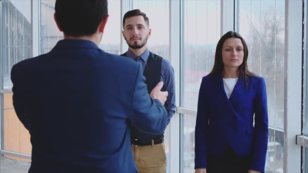 El jefe está dando instrucciones a sus compañeros. Copiar espacio. Los subordinados están molestos. Fondo borroso. De cerca. Vista trasera. 4K. — Vídeos de Stock