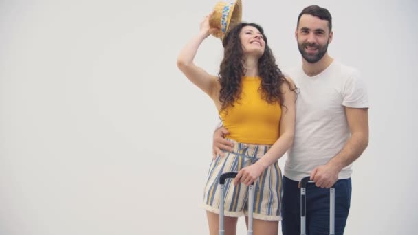 4k slowmotion video af glade unge gift par i kærlighed venter og transporterer kufferter på hjul. – Stock-video