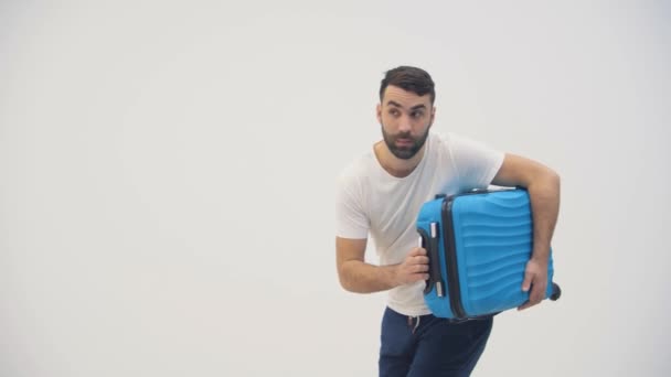 4k slow motion wideo przystojnego mężczyzny niosącego niebieską walizkę. — Wideo stockowe