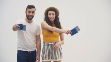 Bavulları ve pasaport biletleri olan neşeli genç çiftin 4K videosu..