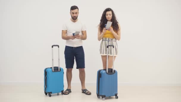 4k video of couple with blue suitcases standing together. — Stock Video