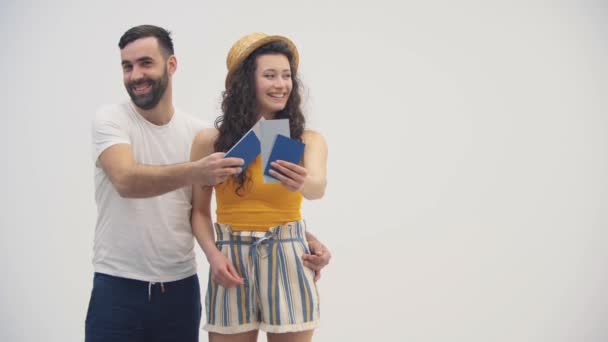 Vidéo 4k de joyeuse femme en chapeau de paille tenant un passeport avec des billets d'avion avec son homme. — Video