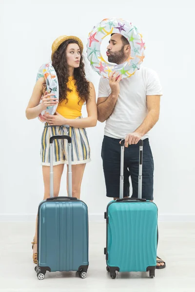 Young couple leaving somewhere on vacations with luggage.
