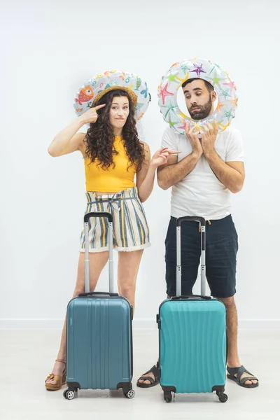 Улыбающаяся пара с паспортами и чемоданами на белом фоне. — стоковое фото