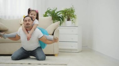 Baba kızıyla oynuyor, onu omuzlarında tutuyor, uçak taklidi yapıyor. Sonra kız ayrılıyor, baba tamamen şaşırmış görünüyor..