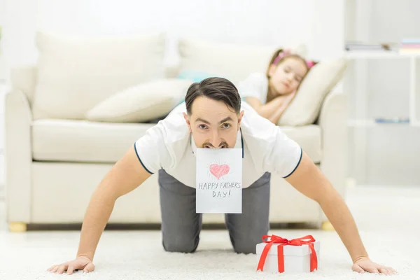 Photo du père gardant sa carte postale dans la bouche. — Photo