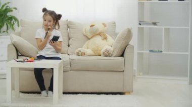 4K videoda küçük bir kız makyaj yapmaya çalışıyor..