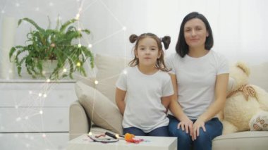 Anne ve kızının beyaz koltukta video için poz verirken 4k yavaş çekim videosu..