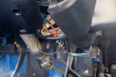 Çok renkli elektrik kablolarının ve konnektörlerin kompleks ve karmaşık düzenini gösteren yakın plan bir araç torpidosu altında, otomatik onarım için kullanışlı