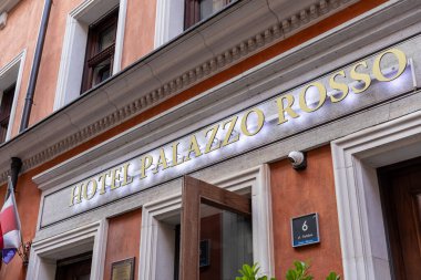 Poznan, Polonya - 31 Ağustos 2025: The HOTEL PALAZO ROSSO tabelası, parıldayan altın harflerle, tarihi bir binanın ön cephesini tanımlıyor. Gotebia, Miasto 'ya bak.