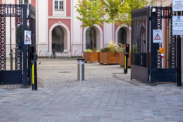 Poznan, Polonya - 31 Ağustos 2025: Süsleme kapısı, bollard, kırmızı trafik ışığı ve tarihi avluya engelli erişimi sağlayan tabelalar