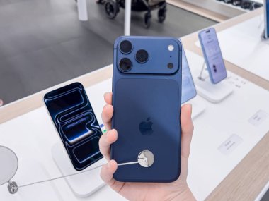Poznan, Polonya - 20 Eylül 2025: iPhone 17 Pro aygıtı bir kişinin elinde, modern bir elektronik mağazası ortamında Apple logosu ile gösteriliyor.