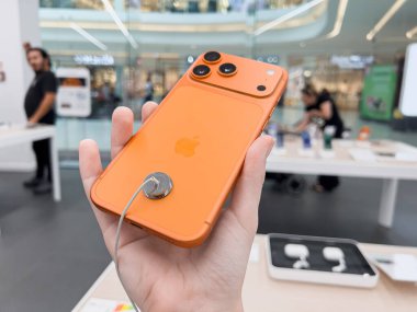 Poznan, Polonya - 20 Eylül 2025: iPhone 17 Pro, gelişmiş üç kameralı şık turuncu akıllı telefon, Premium mobil teknolojiyi keşfeden bir müşteri tarafından incelendi