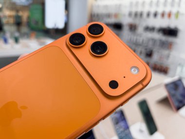 Poznan, Polonya - 20 Eylül 2025: iPhone 17 Pro, canlı turuncu Apple telefon, yakın çekim ileri üçlü kamera, parlak tasarım, logo, mağaza vitrini