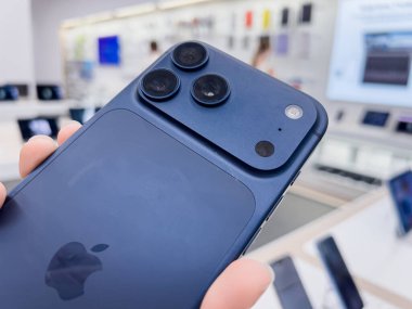 Poznan, Polonya - 20 Eylül 2025: iPhone 17 Pro, bir elektronik mağazasında mobil teknolojinin altını çizerek, mavi arka ve üçlü kamera sistemi sergiliyor