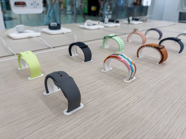 Poznan, Polonya - 20 Eylül 2025: Değişik renk ve materyallere sahip canlı akıllı bantlar, temiz bir perakende masasında gösterilerek, kişiselleştirilmiş teknoloji tarzı sunuldu