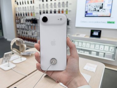 Poznan, Polonya - 20 Eylül 2025: Modern bir Apple perakende mağazasında bir el tarafından tutulan beyaz iPhone Air akıllı telefonu, cep telefonu teknolojisi, zarif tasarım