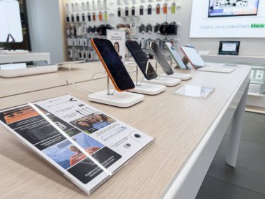 Poznan, Polonya - 20 Eylül 2025: iPhone 17 Pro serisi telefonlar müşteriler için hareketli bir elektronik perakende mağazasının içindeki hafif ahşap bir masada açıkça sergilendi