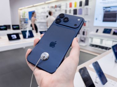 Poznan, Polonya - 20 Eylül 2025: iPhone 17 Pro, bir kişi tarafından tutulan mavi model, ileri teknoloji ve perakende mağazasında güçlü kameralar sergiliyor.