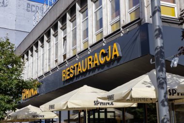 Poznan, Polonya - 20 Eylül 2025: Bir SPHINX restoran binasının manzarası, açık hava terasını Zywiec markalı şemsiyelerle göstermesi, yerel konukseverliği yansıtıyor