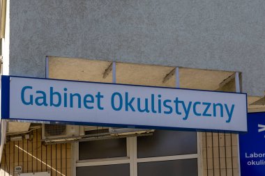 Poznan, Polonya - 20 Eylül 2025: Parlak ışıklı tabelası olan bir binanın dış görünüşü, Gabinet Okulistyczny, uzman görme sağlığı ve tıbbi muayenelere odaklı bir göz hastalıkları kliniği anlamına geliyor