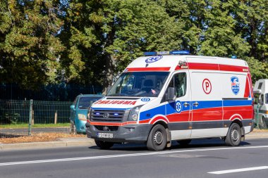 Poznan, Polonya - 20 Eylül 2025: MEDIK24 WZOZ Volkswagen ambulansı güneşli bir şehir yolunda, acil tıbbi ulaşım ve kamu güvenliği operasyonlarını vurguluyor