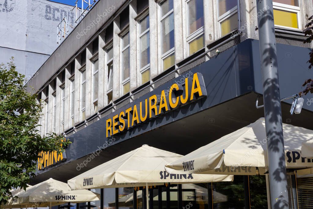 Poznan, Poland - September 20, 2025: View of a SPHINX restaurant building, showcasing its inviting outdoor terrace with Zywiec branded umbrellas, reflecting local hospitality