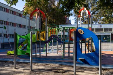 Parlak, güneşli, çocuk dostu çeşitli ekipmanlar, slaytlar, tırmanma yapıları ve güvenlik döşemeleri, aktif oyun ve sağlıklı gelişimi destekleyen boş bir oyun alanı.