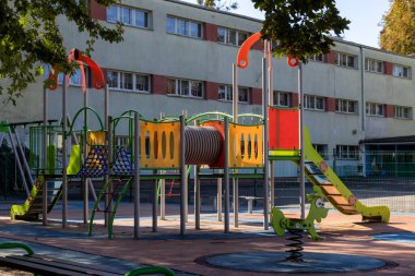 Yumuşak kauçuk döşeme üzerinde kaydırak, ağ, tünel ve bahar binicisinin yer aldığı hareketli bir açık hava oyun alanı, bir topluluk ortamında aktif oyun ve çocuk gelişimi teşvik ediyor