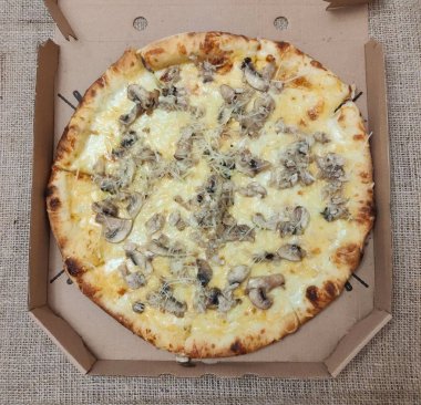 Bir karton kutu içinde mantar ile Pizza