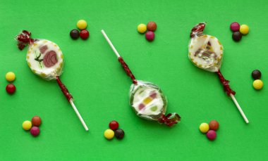 Yeşil bir arka plan üzerinde renkli küçük tatlılar çocuklar.