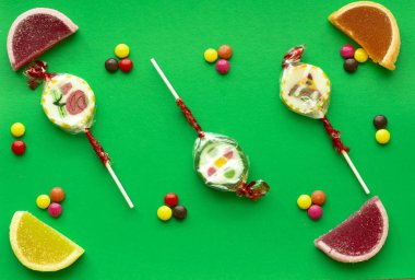 Yeşil bir arka plan üzerinde renkli küçük tatlılar çocuklar.