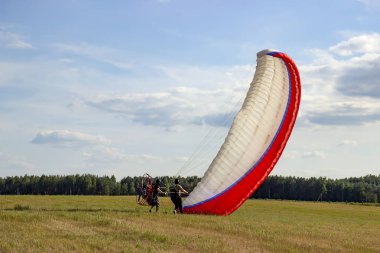 Moto yamaç paraşütü yerde ve havada.